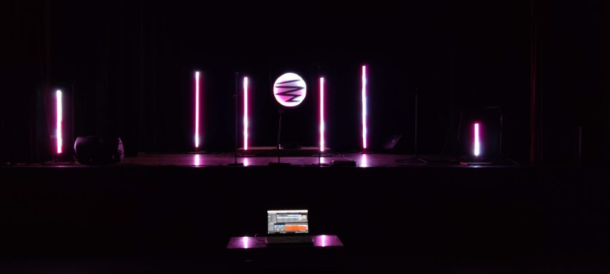L’escenari a les fosques, amb els tubs de llum encesos en rosa.